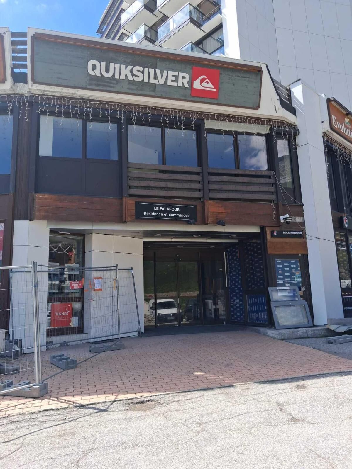 A building with a sign reading 'QUIKSILVER' and 'LE PALAFOUR Residence and commerce' on the ground floor.