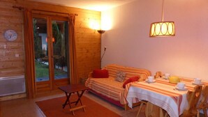 Ein gemütliches Zimmer mit einem Bett, einem Esstisch für zwei Personen und einem kleinen Tisch mit Stühlen.