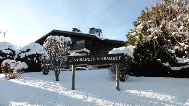 Une enseigne indiquant « Les Granges d’Ormaret », avec un bâtiment en arrière-plan.