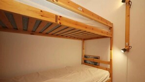 Ein Stockbett mit Holzbettgestell und einer Matratze.