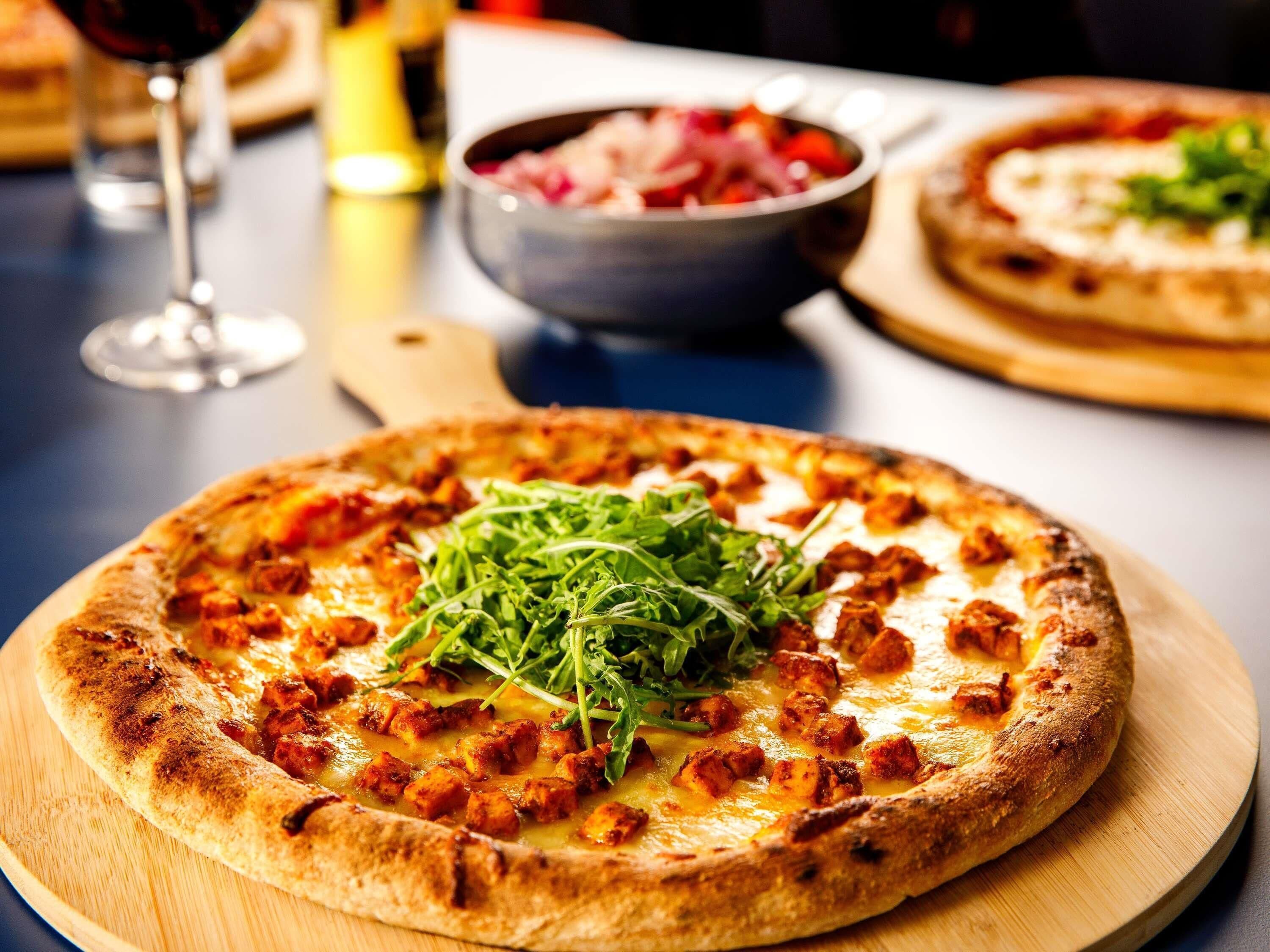 A pizza with toppings on a wooden board.