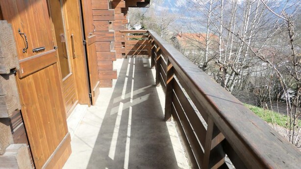 A wooden balcony with a view of trees and buildings. - Chalet, view mountain, tv, 110m², Saint Gervais (Saint-Gervais-les-Bains)