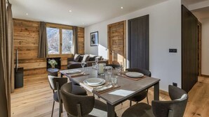 Un comedor moderno con una mesa de madera preparada para cuatro personas, rodeada de sillas.
