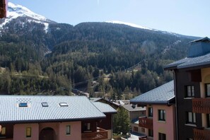A mountain village with buildings surrounded by forest and snow-capped peaks. - 100m from resort center, 3rd floor, view mountain, balcony, tv, ski locker, 33m², Val Cenis (Lanslebourg-Mont-Cenis)