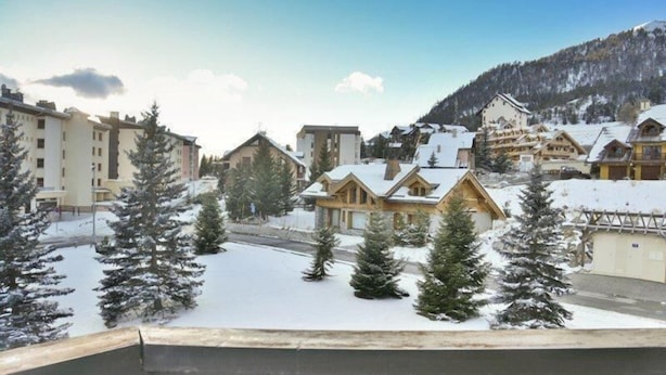 A snow-covered village with traditional wooden houses and a mountain backdrop. - 100m from shops, 2nd floor, view mountain, balcony, parking, tv, ski locker, 18m², Montgenèvre (Montgenèvre)