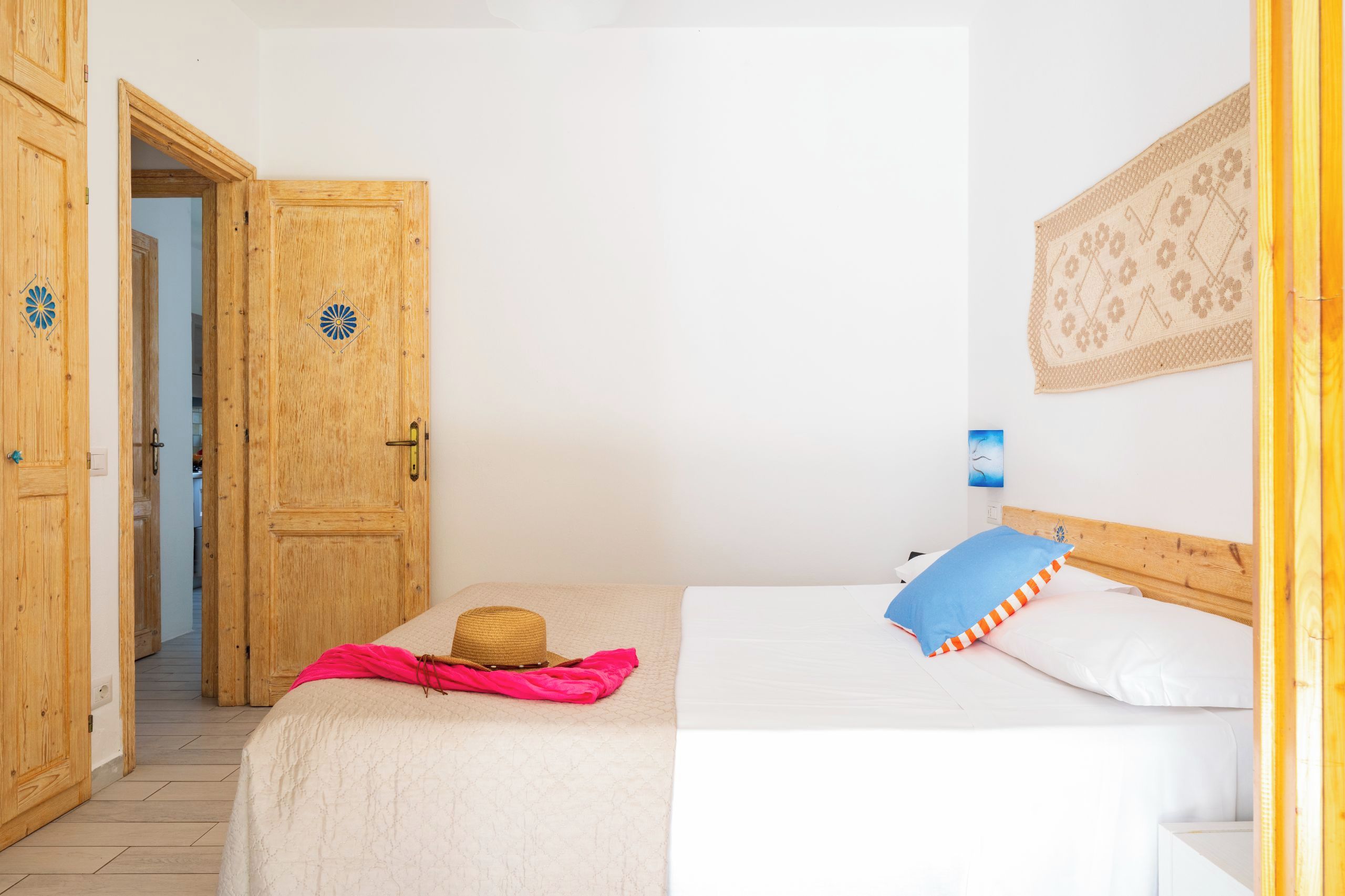 Una stanza con un letto, un cappello e una coperta.