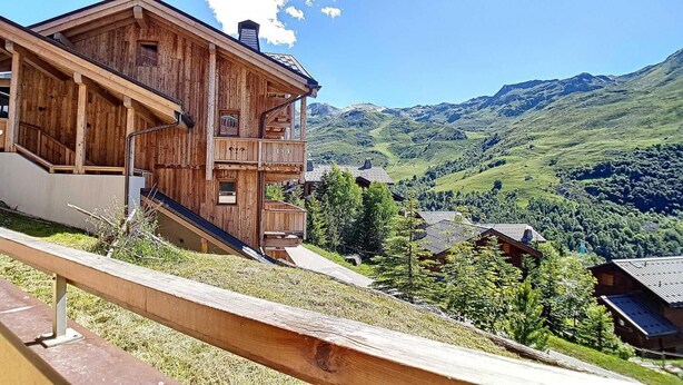 A wooden chalet with a balcony overlooking a mountainous landscape. - 200m from ski slopes, Ground floor, balcony, tv, 50m², Les Menuires (Les Menuires)