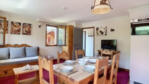 Un comedor acogedor con muebles de madera, un televisor y obras de arte en las paredes.