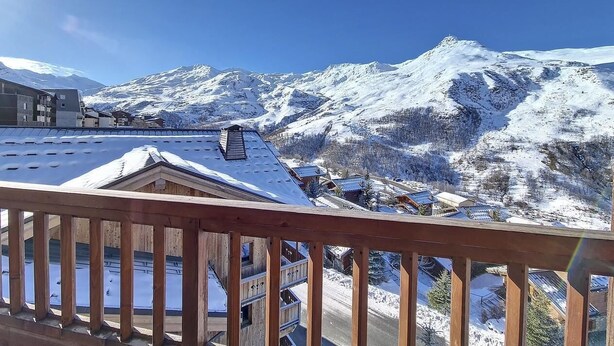 A snow-covered mountain landscape with a wooden balcony overlooking a village. - 200m from ski slopes, 2nd floor, balcony, tv, 85m², Les Menuires (Les Menuires)