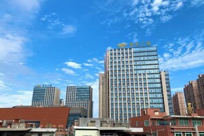A high-rise building with multiple floors and a clear sky. - Hao Fu Hua Hotel (Quanzhou)