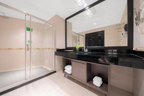 A modern bathroom with a glass shower enclosure, a black countertop, and a large mirror. - Hao Fu Hua Hotel (Quanzhou)