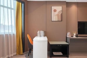 A modern living room with a sofa, a small table, a TV, and a framed artwork on the wall. - Hao Fu Hua Hotel (Quanzhou)