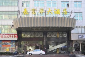 A hotel entrance with a modern design, a car parked in front, and a staircase leading to the entrance. - Hao Fu Hua Hotel (Quanzhou)