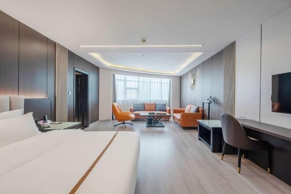 A modern hotel room with a large bed, a desk, two armchairs, a sofa, and a TV. - Hao Fu Hua Hotel (Quanzhou)