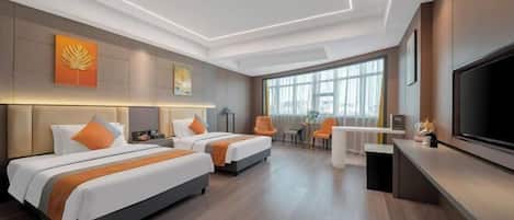 A hotel room with two beds, a TV, a desk, and a large window.