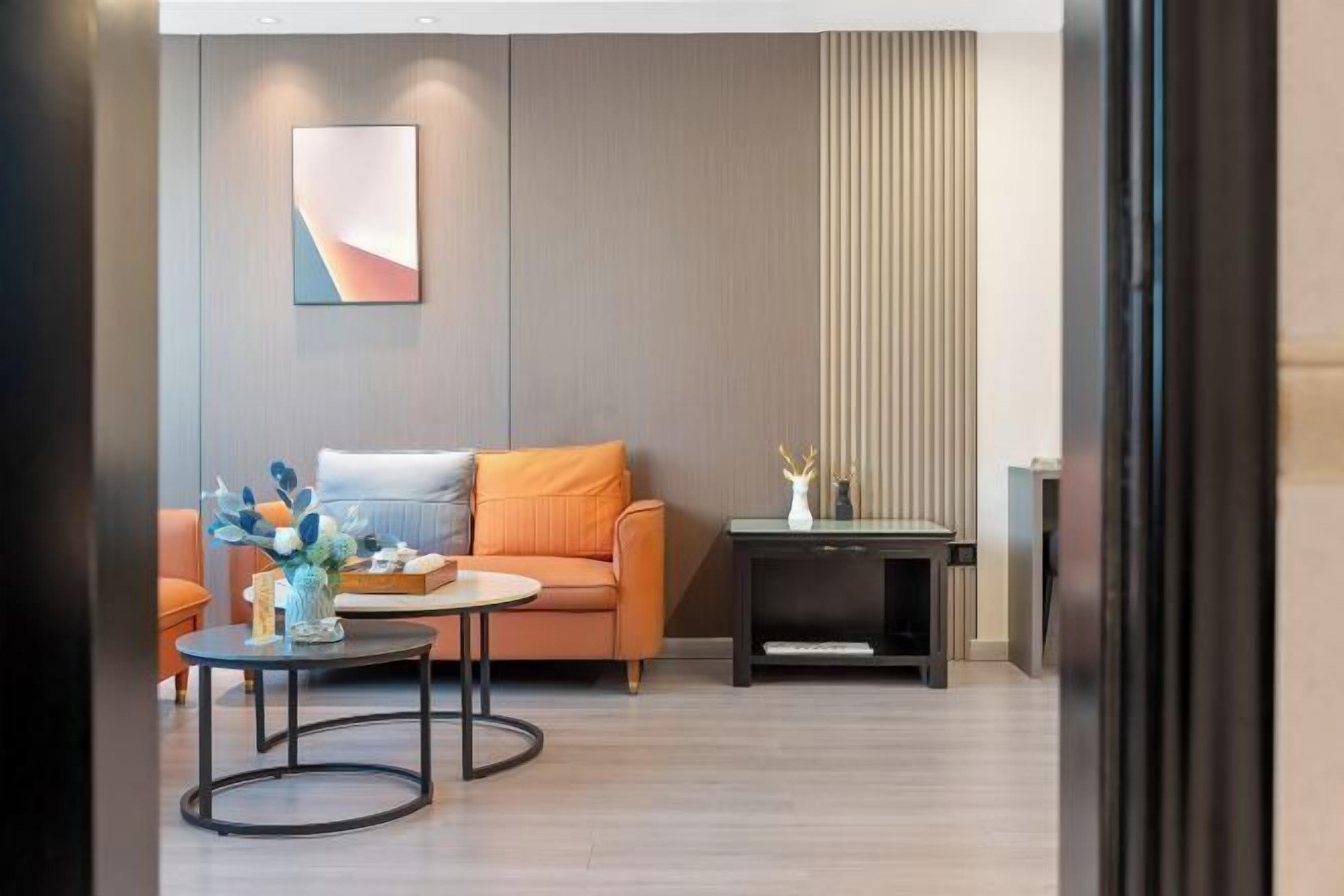 Een moderne woonkamer met een bank, salontafel en bijzettafeltje met een vaas.