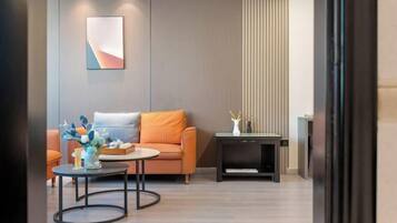 Een moderne woonkamer met een bank, salontafel en bijzettafeltje met een vaas.