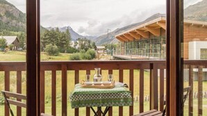 A wooden deck with a table set for two, overlooking a mountainous landscape. - 100m from shops, 1st floor, view street, 32m², Serre Chevalier (SERRE CHEVALIER)