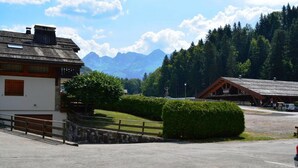 Ein Parkplatz mit einem Gebäude, das eine Holzfassade und eine Steinmauer hat.