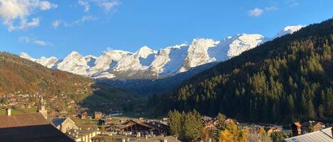 A mountain village with traditional buildings and a view of snow-capped peaks.