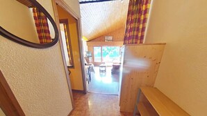 A narrow hallway with wooden flooring and a bench on the right. - 3rd floor, view mountain, balcony, tv, 41m², Le Grand Bornand (Le Grand-Bornand)