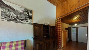A cozy living room with a wooden cabinet, a plaid sofa, and a wooden ceiling. - 3rd floor, view mountain, balcony, tv, 41m², Le Grand Bornand (Le Grand-Bornand)