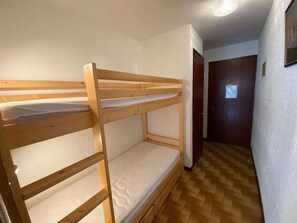 A bunk bed room with a wooden floor and white walls. - Ground floor, balcony, tv, 26m², Le Grand Bornand (Le Grand-Bornand)