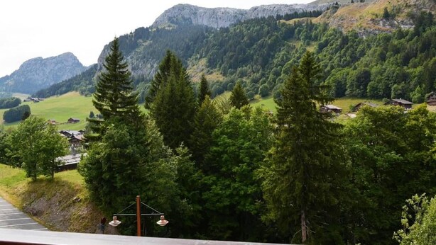 A mountain landscape with a road leading to a village. - 100m from ski slopes, Ground floor, balcony, tv, 26m², Le Grand Bornand (Le Grand-Bornand)