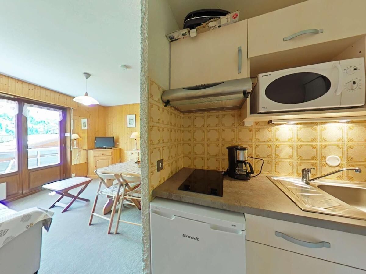 A compact kitchen with a microwave, coffee maker, and a dishwasher.