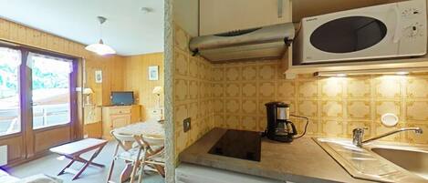 A compact kitchen with a microwave, coffee maker, and a dishwasher.