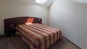 A bedroom with a bed, a nightstand, a lamp, and a skylight. - 100m from ski slopes, 2nd floor, view ski slopes, jacuzzi, hammam, parking, tv, ski locker, 66m² (Germ)