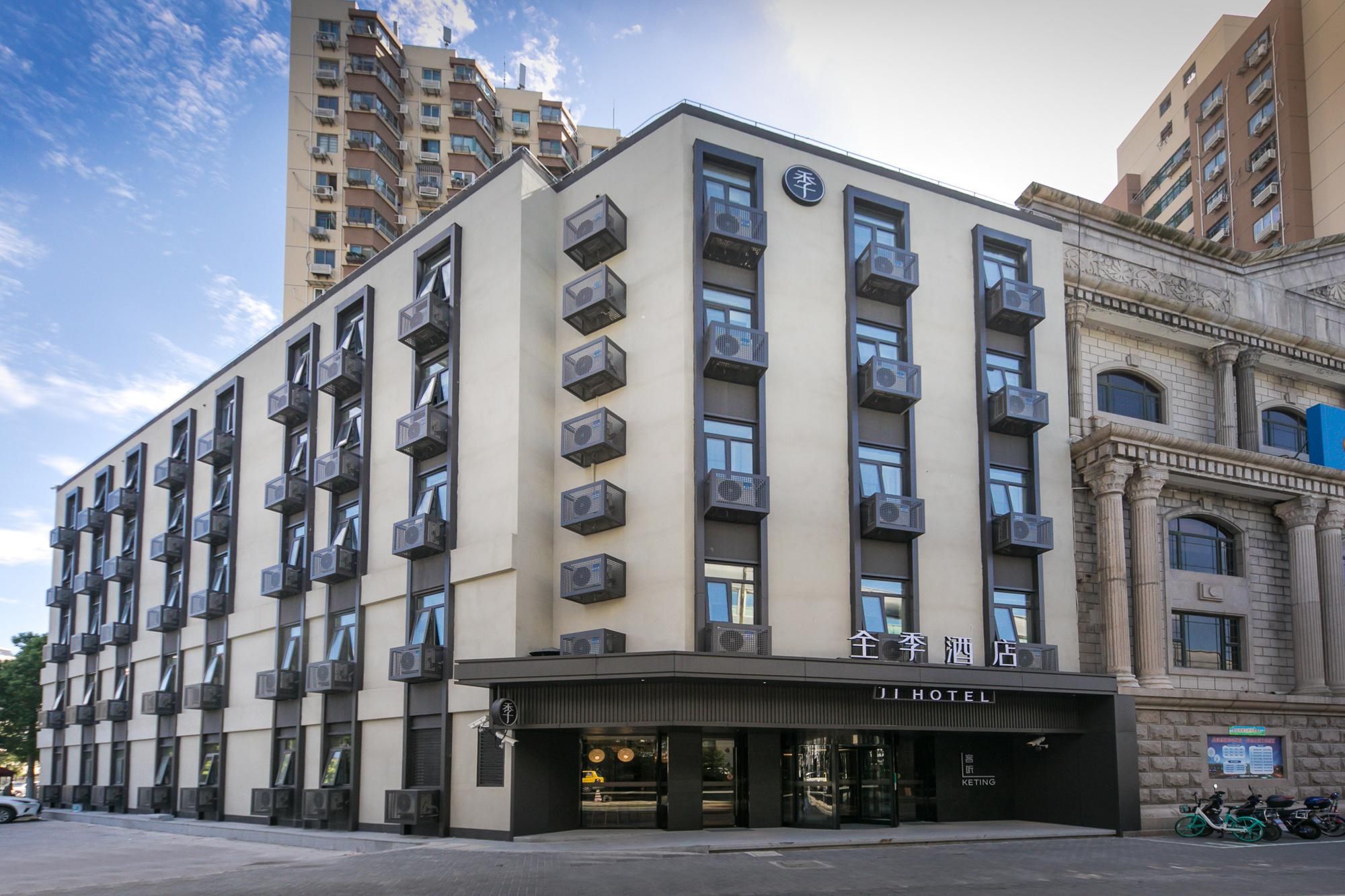 A hotel with multiple floors, air conditioning units, and a sign indicating it's a hotel.