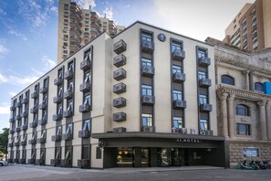 A hotel with multiple floors, air conditioning units, and a sign indicating it's a hotel. - Ji Hotel (Shanghai)