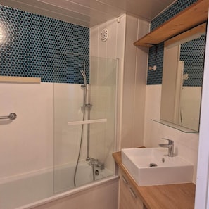 A modern bathroom with a glass-enclosed shower, a white sink, and a mirror above it. - 200m from ski slopes, 7th floor, balcony, tv, 35m², Val Thorens (Val Thorens)