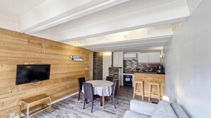 Un interior moderno con una pared de madera, una mesa redonda de comedor y un sofá.