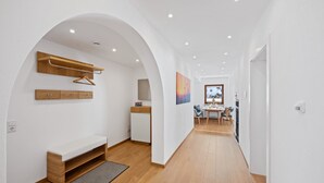 A modern interior with a bench, wooden shelving, a dining area, and a kitchen. - Enjoy the new vacation apartment in a prime location with a 10% weekly discount (Bad Kohlgrub)