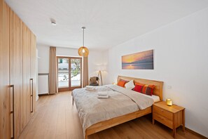 Une chambre à coucher avec un lit, une table de chevet et une vue sur l’extérieur.