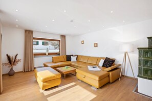 Un salon moderne avec un canapé d’angle, une table basse et un lampadaire.