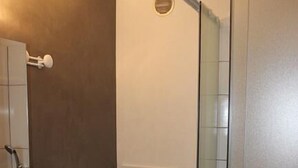 Ett badrum med toalett, handfat och dusch med glasväggar.