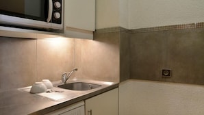 A kitchen with a microwave, sink, and dishwasher.