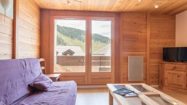 A wooden cabin with a sofa, a coffee table, and a TV. - 250m from ski slopes, 1st floor, view ski slopes, balcony, tv, 28m², Montgenèvre (Montgenèvre)
