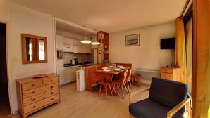 A compact living space with a dining area, kitchenette, and a small seating area.