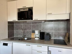 A compact kitchen with a microwave, coffee maker, and knife block. - 220m from resort center, 5th floor, view village, balcony, parking, tv, 25m², Montgenèvre (Montgenèvre)