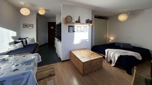 A compact room with a bed, a small table, and a kitchenette. - 220m from resort center, 5th floor, view village, balcony, parking, tv, 35m², Montgenèvre (Montgenèvre)