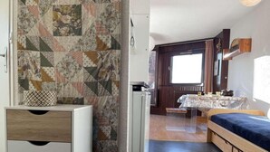 A compact room with a bed, a small table, and a cabinet. - 220m from resort center, 5th floor, view village, balcony, parking, tv, 35m², Montgenèvre (Montgenèvre)