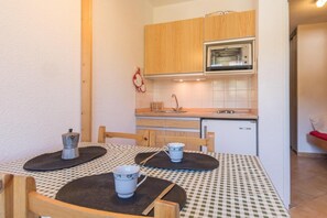 A compact kitchen with wooden cabinets, a built-in oven, and a small sink.