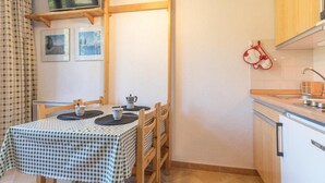 A small kitchen with a table set for two, a sink, and a microwave. - 2nd floor, view mountain, balcony, parking, tv, 20m², Montgenèvre (Montgenèvre)