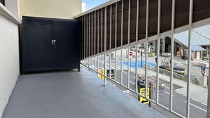 Ein Balkon mit Metallgeländer, der auf eine Straße blickt.