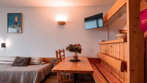 A cozy room with a wooden table, bench, and a bed with a quilted blanket.