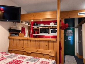 A bedroom with a wooden bunk bed, a flat-screen TV, and a kitchenette with a microwave and toaster oven. - 1st floor, view valley, tv, 40m², Les Arcs (Les Arcs)